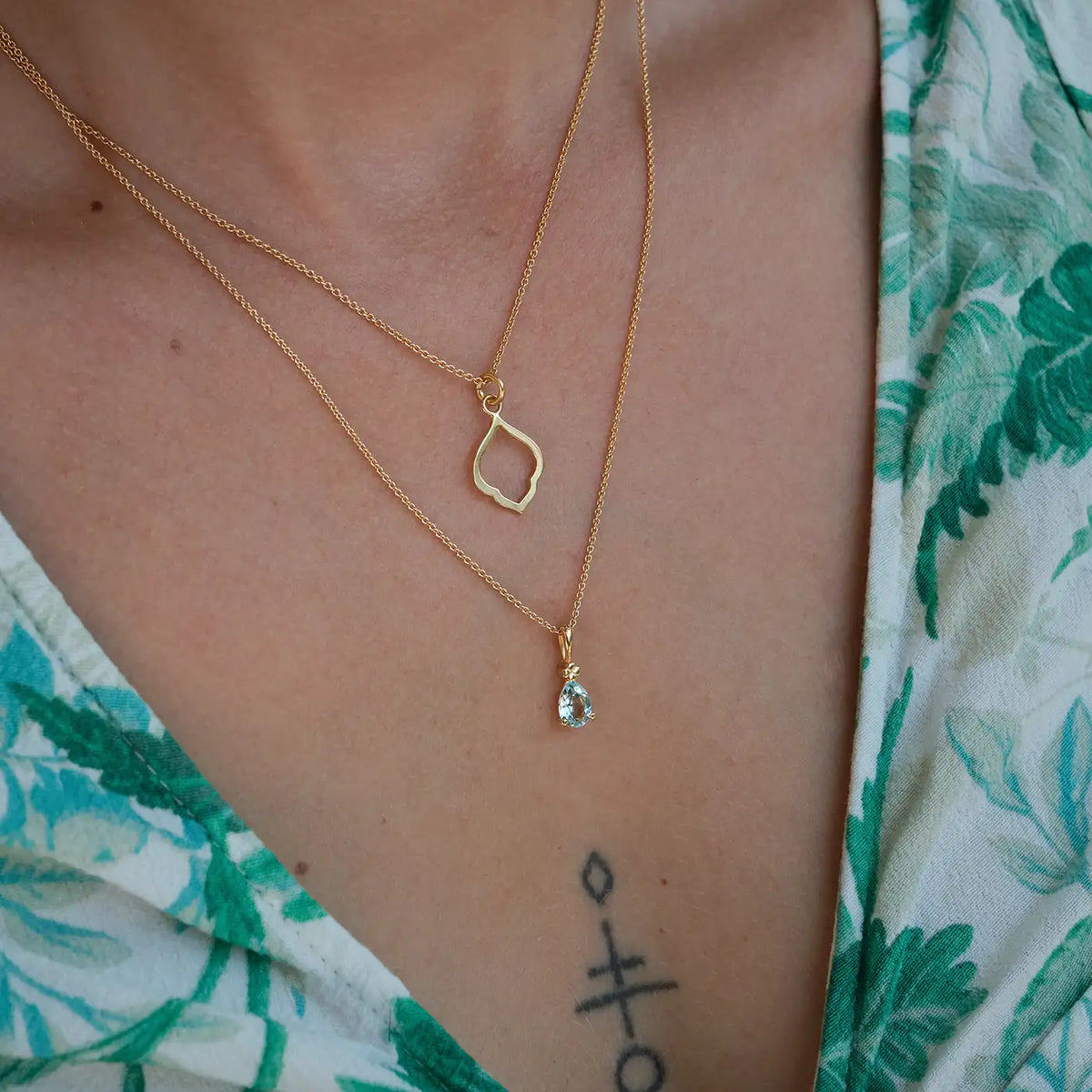 Kette Leaf klein und Kette Blossom hellblauer Topas aus 925er Sterlingsilber vergoldet - am Hals getragen, Nahaufnahme